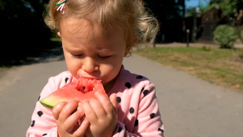 The child eats watermelon in summer. Selective focus. Video stock 213627288