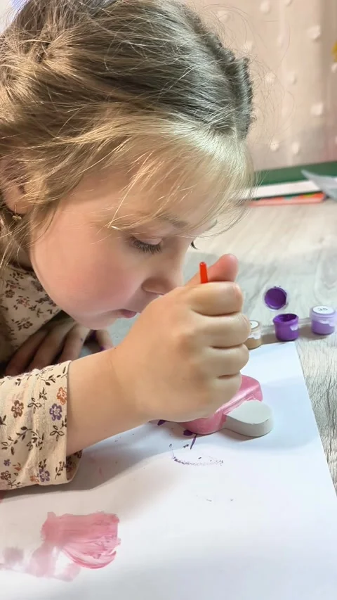 Child engaged in painting plaster model, Stock Footage 344552254