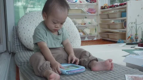 Child Engaged with a Tablet in a Playful Environment Stock Footage 343556807