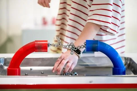 Child engaging with a hands-on science exhibit, demonstrating magnetic forces Stock Photos