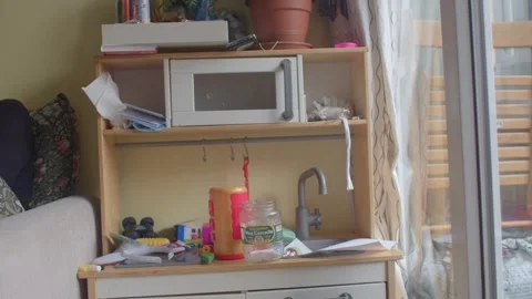 A Child Engaging in Play at a Desk Surrounded by Colorful Toys and Art Supplies Stock Footage 311117905