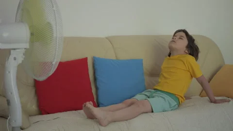 Child Enjoying Cool Wind From Electric Fan at Home at Summer Heat Weather. .. Video stock 343588408