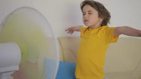 Child Enjoying Cool Wind From Electric Fan at Home at Summer Heat Weather. .. Video stock 343589131