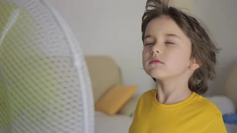 Child Enjoying Cool Wind From Electric Fan at Home at Summer Heat Weather. .. Video stock 343650485