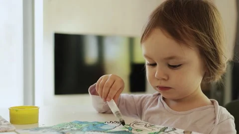 The child is enjoying a creative coloring activity at home, enhancing their Stock Footage 309048129