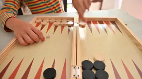 Child enjoying a game of backgammon with striped shirt Stock Footage 290051299