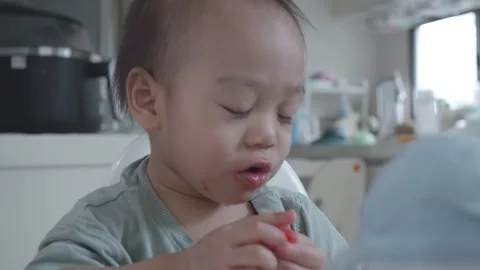 Child Enjoying Snack in a Bright Kitchen Environment Vidéo 344032191