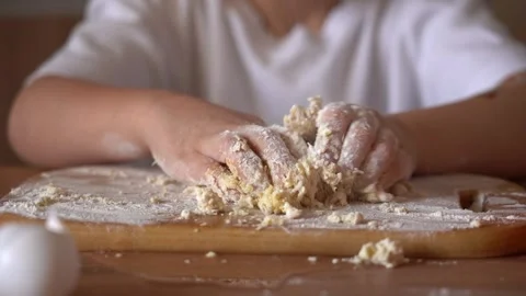 Child enjoys making dough from scratch in home kitchen while learning baking Stock Footage 312631996