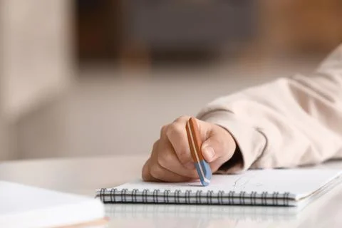 Child erasing mistake in notebook at table, closeup Foto stock