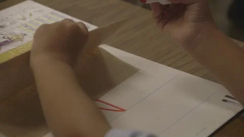 Child erasing red marker off of small whiteboard Stock Footage 304372741