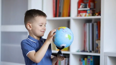 A child examines a globe while holding it in his hands Stock Footage 129266429