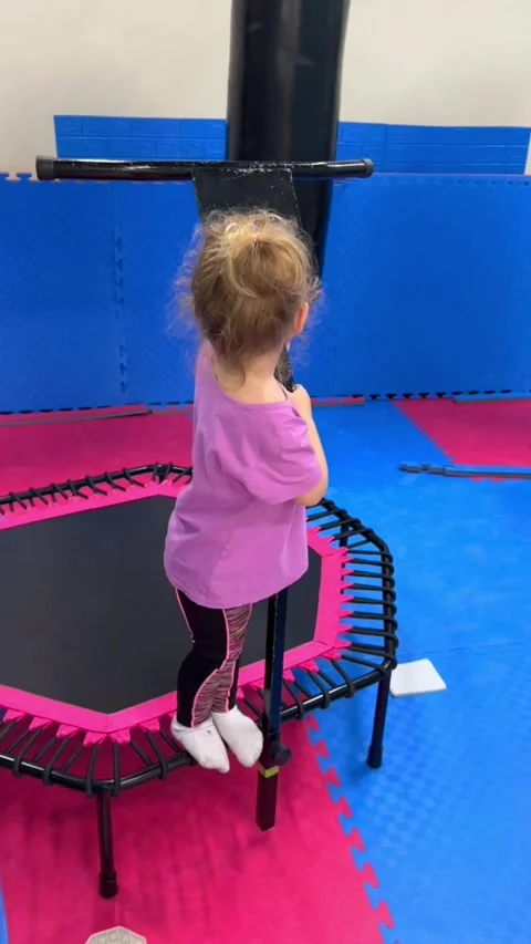 Child exercising on mini trampoline in gym. Little girl jumping during fitness Stock Footage 339432003