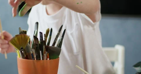 Child experiments with different brush sizes during lesson Video stock 277338252