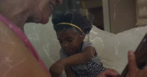 Child exploring lap device while senior woman guiding after tapping phone, Stock Footage 330602173