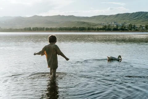 Child Exploring Nature and Learning Through Outdoor Play by the Lake Stock Photos
