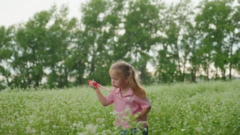 Child exploring nature while girl flies small toy airplane, Young child ventures Stock Footage 329539621