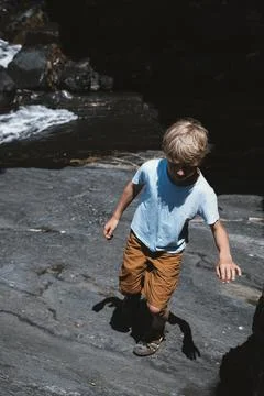 Child Exploring Rocky Terrain by a Stream Stock Photos