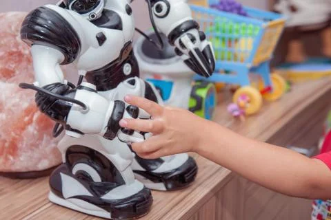 The child extends a hand to the robot. The concept of friendship between the Stock Photos