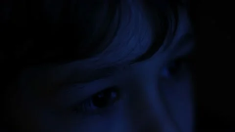 Child eye close-up tablet screen display. Monitor blue light is reflected in her Video stock 233728924