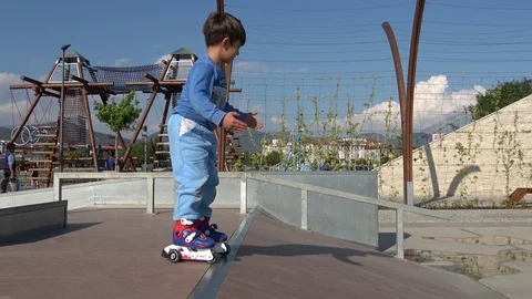 Child falls down very hard on his arm and hip when learning roller skating Stock Footage 107269954