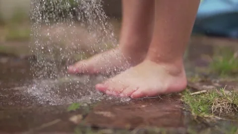Child feet on the wet pavement Stock Footage 80237942