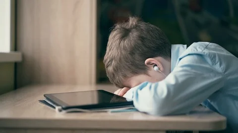 Child fell asleep while he was doing his homework, listening to the audiobook. Stock Footage 105099877