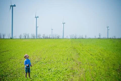 Child on the field with wind generators Stock Photos