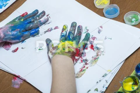 A Child Finger Painting On Paper