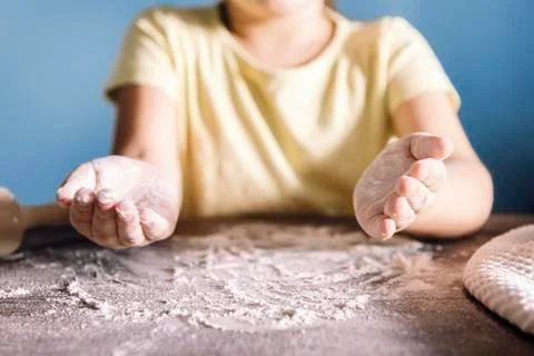 Child with floured hands on the kitchen table Stock Photos