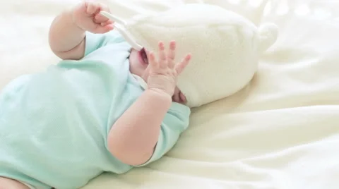 Child in a fluffy hat plays in bed. Stock Footage 63418963