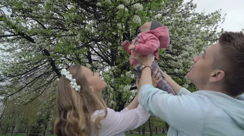Child flying on his parent 's hands slow motion Stock Footage 62465497