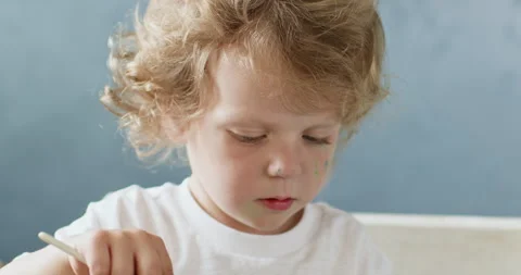 Child focused in drawing with hands covered in paint Vidéo 277337732