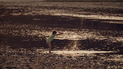 The child is fooling around in the river Vídeos de archivo 94242352