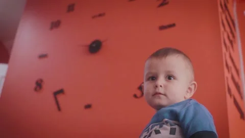 Child in Front of a Wall Clock Stock Footage 199659454