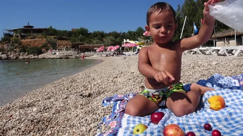 Child with fruit lunch on the beach Stock Footage