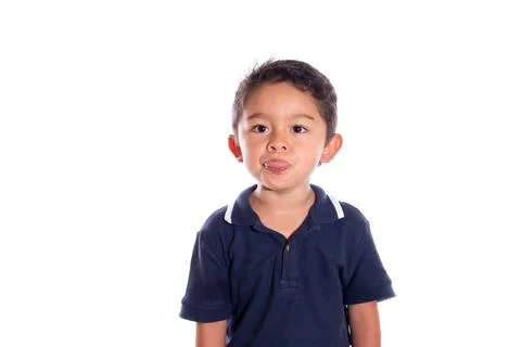 Child gesturing to camera, isolated on white background. Latin boy making faces Stock Photos