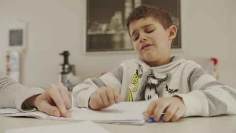 Child gets angry while doing school homework at home because of the lockdown Stock Footage 131723483
