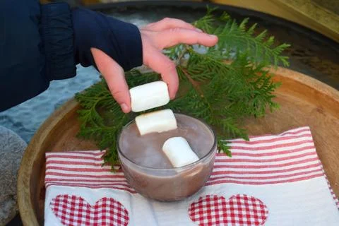 The child gets marshmallows and cups of cocoa. Stock Photos