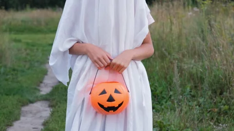 Child in ghost Halloween costume posing outdoors 動画素材 315218184