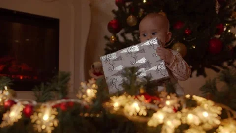 Child with gift box by the christmas tree Stock Footage 142146378