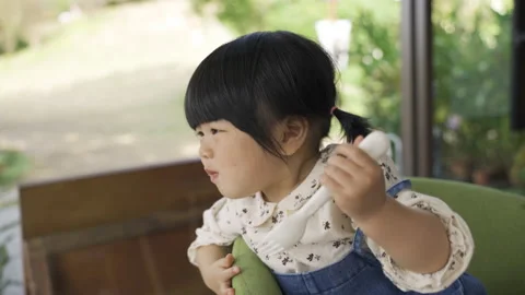 Child girl looking outside while eating Video stock 205867197