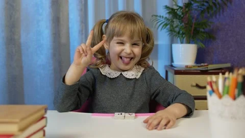 Child girl looking at web camera making video call, studying lessons at home Vidéo 147241699