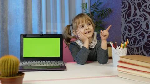 Child girl studying e-learning, distance education, kid pointing at laptop green Stock Photos