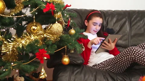 Child girl using tablet pc near Christmas tree Stock Footage 52017829