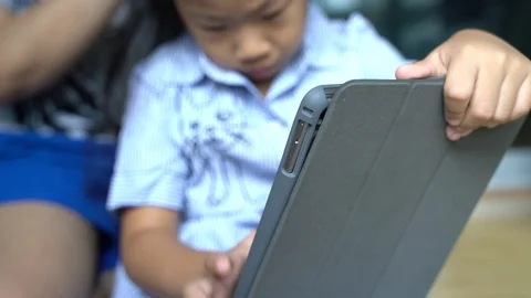 Child girl using tablet pc in room with mother Stock Footage 106946378
