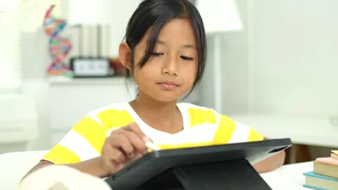 Child girl watching online tutorial and drawing digital pictures using digi.. Stockbeeldmateriaal 331335936
