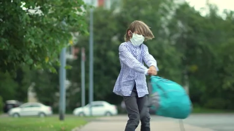 Child goes back to school. Cute pupil with backpacks. Boy in safety masks Stock Footage 137085866