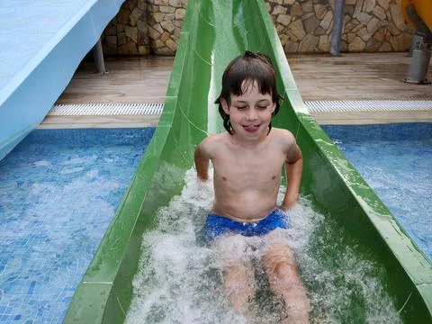 Child going down the slide in the pool Stock Photos
