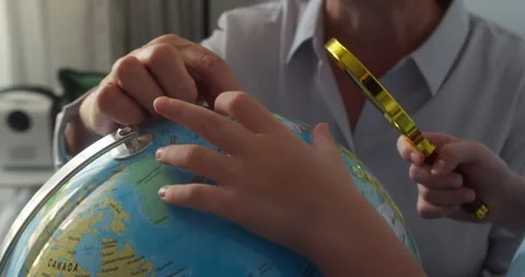 Child with grandma is studying while sitting at home in rays sunset in room. Kid Stock Footage 307351059