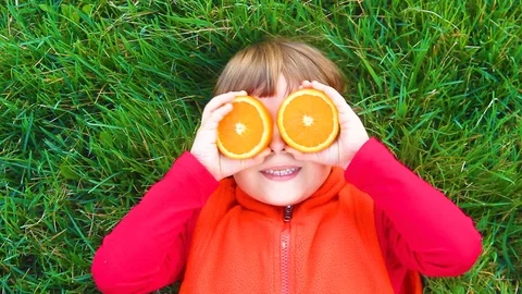 Child on green grass with oranges. Stock Footage 88671279